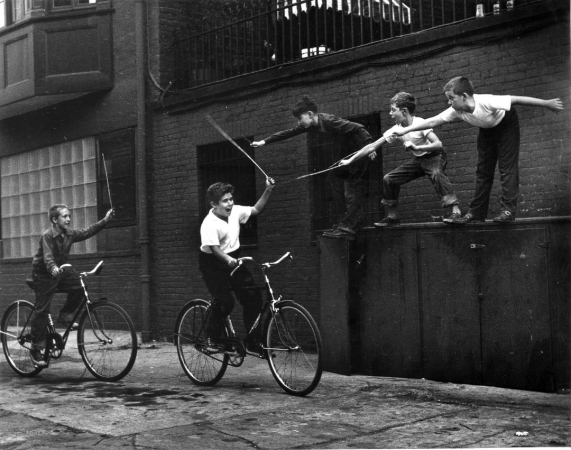 Benn Mitchell, Two boys charging on bicycles, 1949