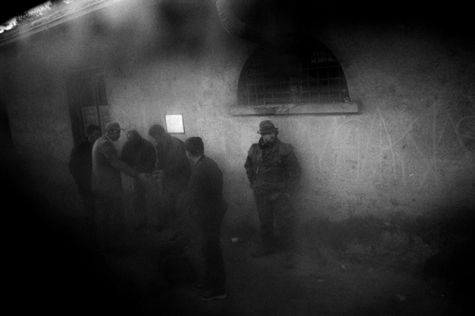 Paolo Pellegrin<br /> <em>Serb men and KFOR soldiers, Town of Zvecan, EX-YUGOSLAVIA. Kosovo. 2001</em><br /> Pigment ink print<br />20 x 24” &nbsp; &nbsp;Edition of 10 plus 2 APs<br /> 30 x 40” &nbsp; &nbsp;Edition of 5 plus 2 APs<br /> 48 x 70” &nbsp; &nbsp;Edition of 3 plus 2 APs