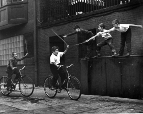 Benn Mitchell, Two boys charging on bicycles, 1949